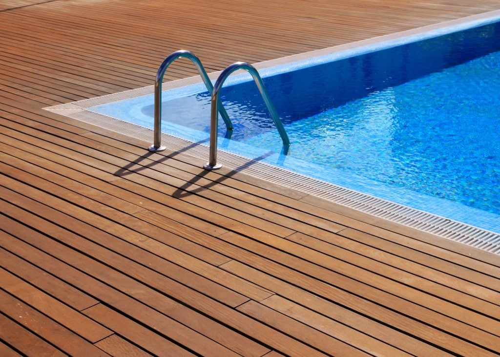 A wrap around deck is installed with a pool in a residential property.
